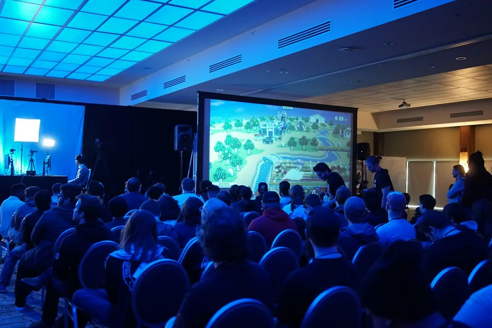 Sala de conferencias con público y pantalla de proyección